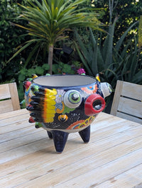 Colorful ceramic owl planter on a wooden table outdoors.