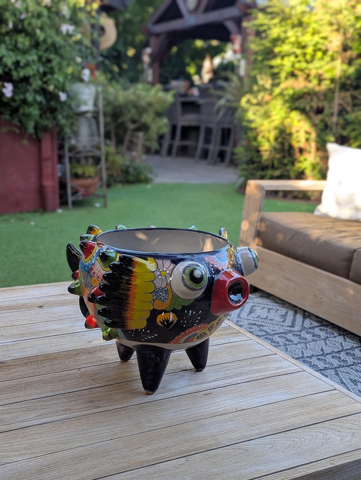 Colorful ceramic plant pot with unique design on a patio