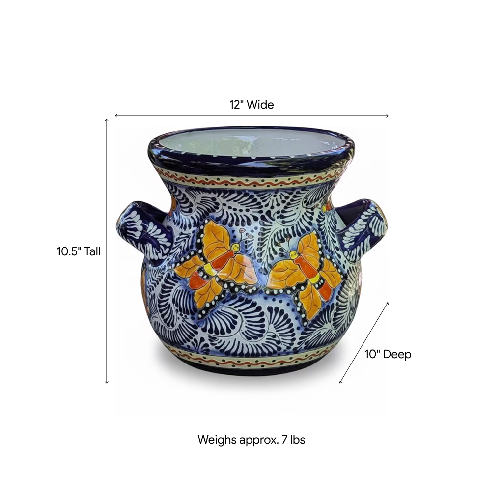 A decorative ceramic planter pot with a blue and white hand-painted floral pattern and two orange butterflies, shown with dimension lines indicating 12 inches wide, 10.5 inches tall, 10 inches deep, and a weight of approximately 7 lbs.