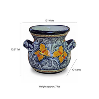 A decorative ceramic planter pot with a blue and white hand-painted floral pattern and two orange butterflies, shown with dimension lines indicating 12 inches wide, 10.5 inches tall, 10 inches deep, and a weight of approximately 7 lbs.