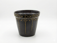 Black pot with gold decorative patterns on a white background