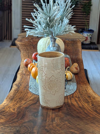 Ceramic mug with autumn-themed decorations on a wooden table