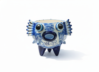 Blue and white ceramic creature figurine on a white background