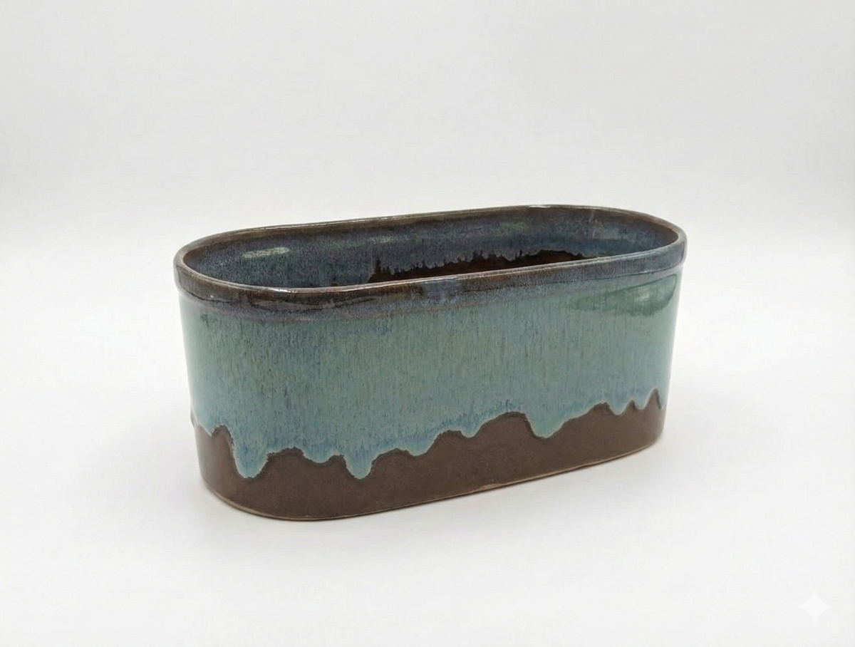 Oval ceramic planter with two-tone glaze on a white background