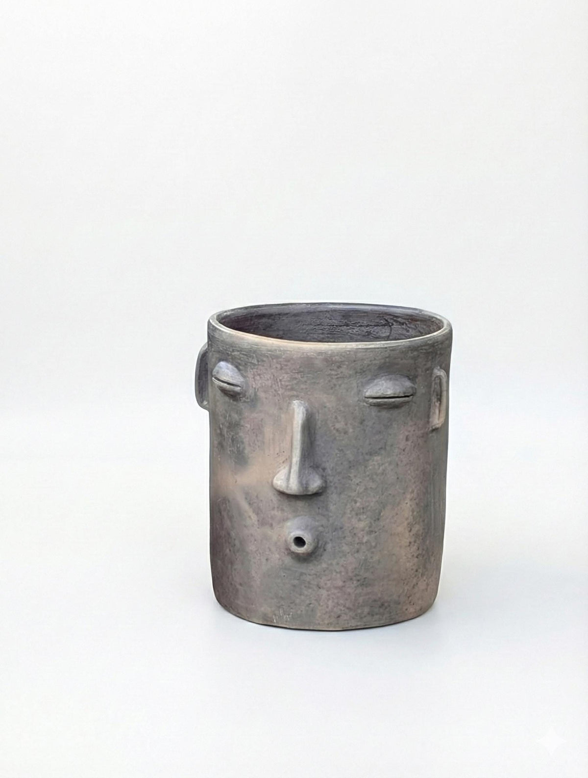 Ceramic face-shaped planter on a white background