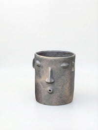 Ceramic face-shaped planter on a white background