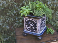 Decorative ceramic planter with herbs on a wooden surface